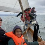 Volunteer on bowsprit with kids