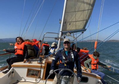 Smiling helmsman with school group on Pegasus